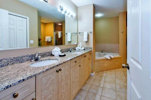 a bathroom with two sinks and a large mirror at WQR Private Rentals No Resort Pool Access in Orlando