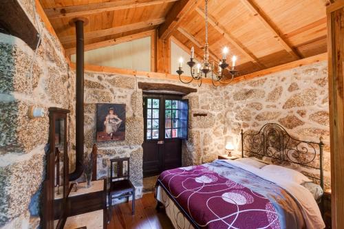 a bedroom with a bed in a stone wall at Chalé da Quinta "Lavoura da Bouça - Fruta Bio" in Celorico de Basto