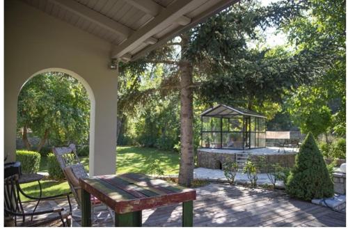 a patio with a wooden bench and a gazebo at River country in Kalavrita
