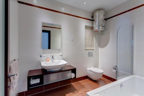 a white bathroom with a sink and a toilet at Seaview Apartment In Fort Cambridge, Sliema in Sliema