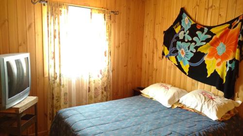 een slaapkamer met een bed en een televisie bij Bonita casa con vista al mar Las Cruces El Tabo in Las Cruces