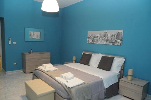 ein Schlafzimmer mit einem großen Bett mit blauen Wänden in der Unterkunft Same as home in Caserta