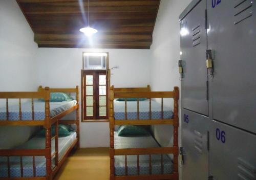 a room with three bunk beds in a room at Livina Hostel in Paraty