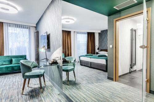 a hotel room with a bed and a desk and chairs at Hotel Traugutta3 in Białystok