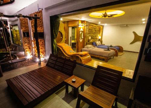 AC 2 Resort في كو تاو: غرفة معيشة مع مقعد وغرفة نوم
