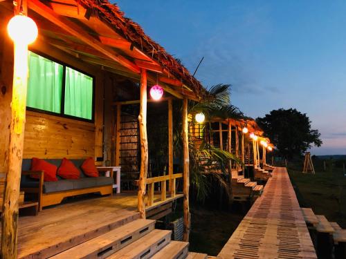 a wooden cabin with lights on the porch at night at Moon Nest in Dhoāpālong