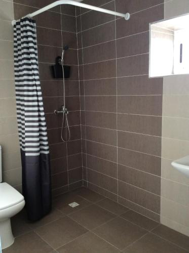 a shower with a black and white shower curtain in a bathroom at Palm Grove Farm in Tit Mellil