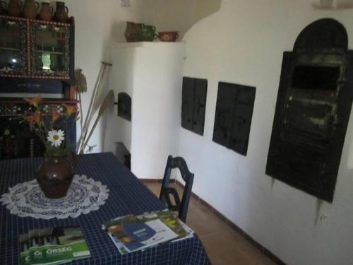 a room with a table with a vase on it at Múltidéző Porta - Népi Műemlék Házak az Őrségben in Szalafő