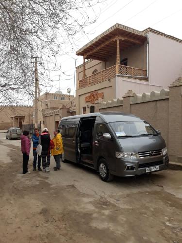 a group of people standing next to a black van at Guest House Orzu in Khiva