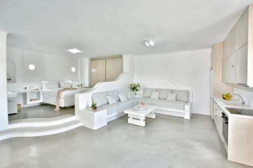 a white living room with two white couches and a table at AC Village Christoulis in Mýkonos City
