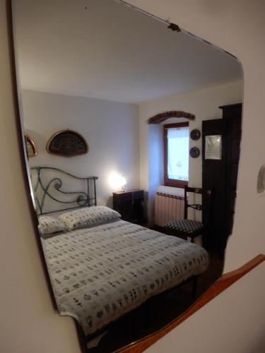 a reflection of a bedroom with a bed in a mirror at Il Borgo della Colomba in Fosdinovo