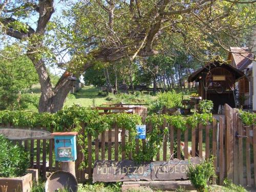 a garden with a wooden fence and a gazebo at Múltidéző Porta - Népi Műemlék Házak az Őrségben in Szalafő