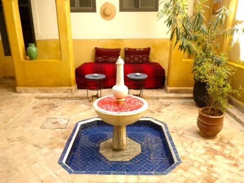 a fountain in the middle of a room with a couch at Riad Laila in Marrakech
