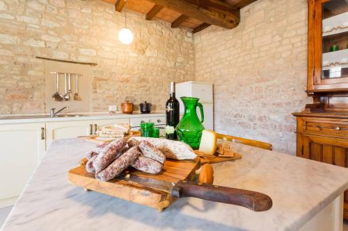 een keuken met een tafel met brood op een snijplank bij Villa Costanzi: Beautiful Rural Apartment! in Sigillo