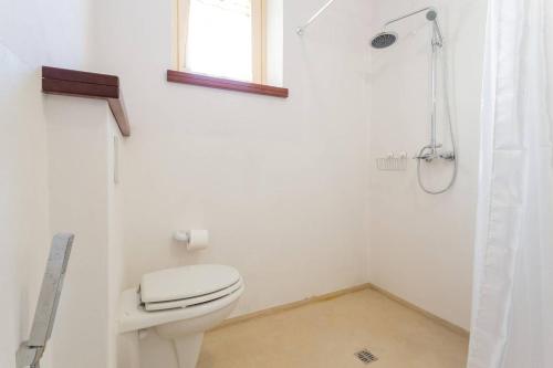 a white bathroom with a toilet and a shower at Villa Costanzi: Beautiful Rural Apartment! in Sigillo
