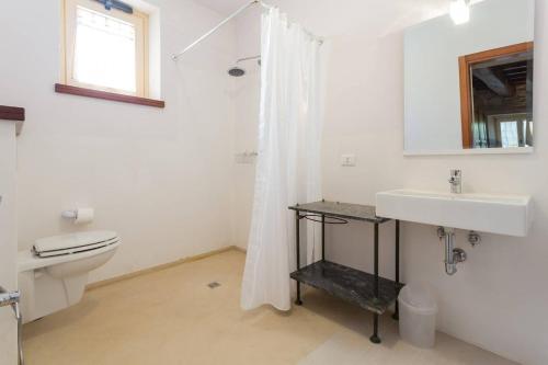 a white bathroom with a toilet and a sink at Villa Costanzi: Beautiful Rural Apartment! in Sigillo