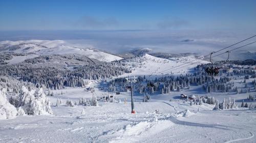 a ski lift on top of a snow covered mountain at Apartman Sladjana Premier 12 Milmari in Kopaonik