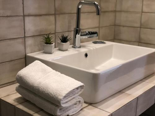 a white sink with towels on a counter in a bathroom at Votsalo in Kavala