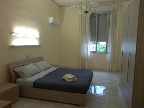 ein Schlafzimmer mit einem Bett mit einer blauen Decke und einem Fenster in der Unterkunft Appartamento Via Vulcano in Trapani