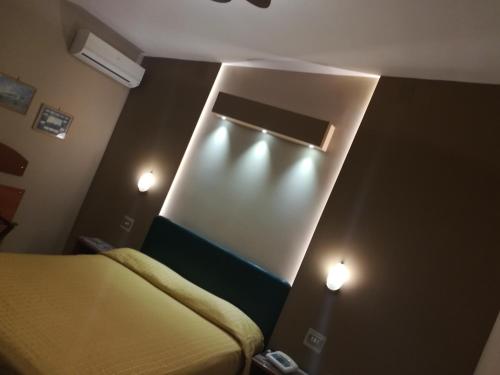 sypialnia z łóżkiem i 2 lampkami na ścianie w obiekcie Hotel Lento w mieście Melito di Napoli