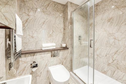 a bathroom with a toilet and a shower at Terlon Apartments in Liverpool