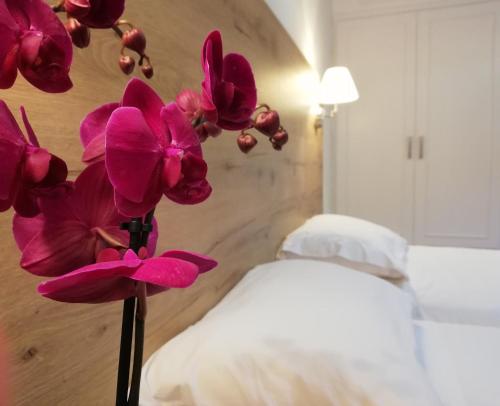 a vase filled with purple flowers in a bedroom at The Mathraki Studios (Adult Only) in Arillas