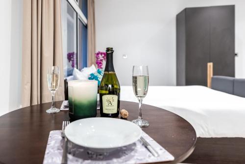 a table with a bottle of wine and two glasses at Terlon Apartments in Liverpool