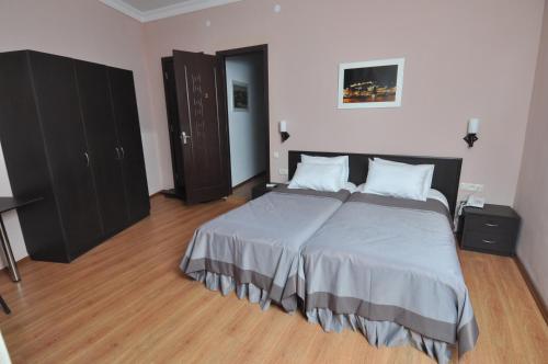 a bedroom with a large bed and wooden floors at Hotel Corner in Tbilisi City