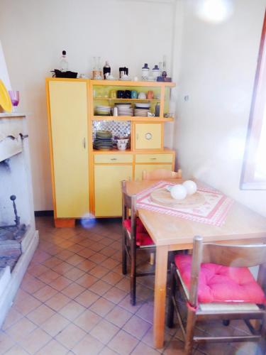 a kitchen with a table and a yellow cabinet at Il Borgo della Colomba in Fosdinovo