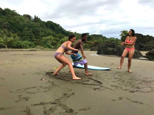 a group of people standing on a beach with a surfboard at The Humpback Turtle in El Valle