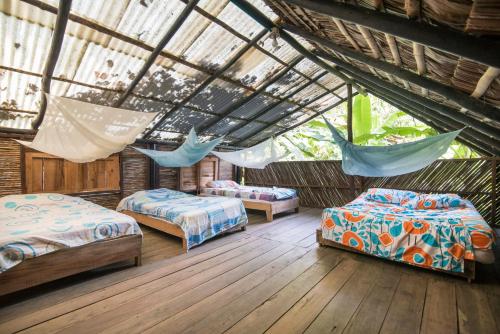 a room with two beds and hammocks in it at The Humpback Turtle in El Valle