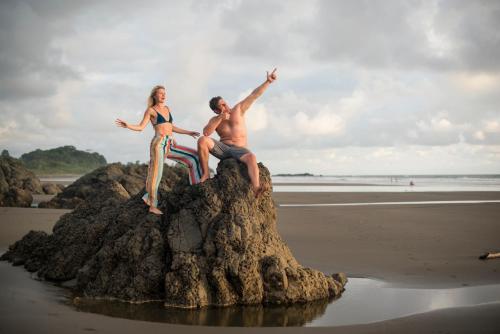 a man and a woman sitting on a rock on the beach at The Humpback Turtle in El Valle