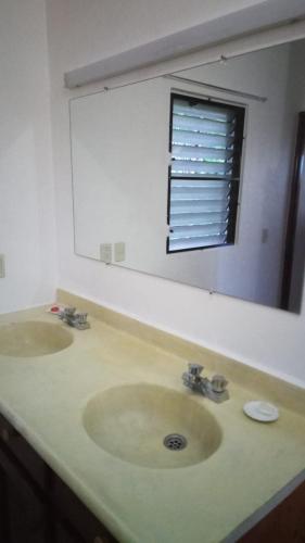 a bathroom with two sinks and a large mirror at Ruhig, gross mit herrlicher Aussicht in San Felipe de Puerto Plata