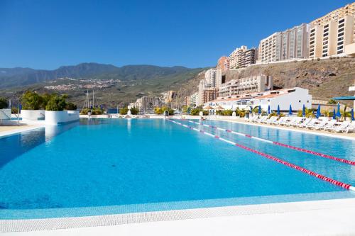 a large swimming pool with chairs and buildings at Radazul Marina Seafront 13 in Radazul