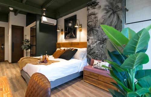 a bedroom with a bed and a table and a plant at Celestino Boutique Hotel in Medellín