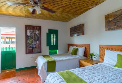 a bedroom with two beds and a ceiling fan at Hacienda Juanita in Maricao