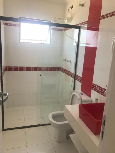 a bathroom with a glass shower and a toilet at Casa do Saí in Guaratuba