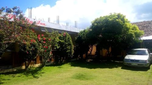 a car parked in a yard next to a house at Villa Peralta Inn in Donsol