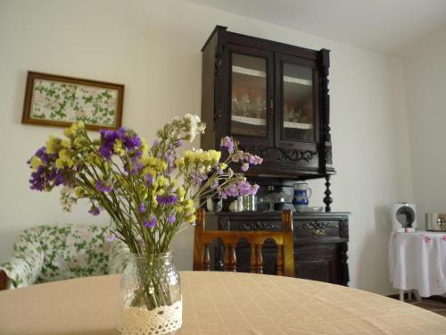 a vase filled with purple and yellow flowers on a table at Las Hazas Jarandilla de la Vera in Jarandilla de la Vera