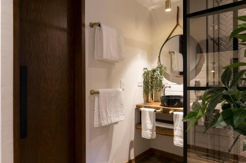 a bathroom with white towels and a mirror at Celestino Boutique Hotel & Spa in Medellín