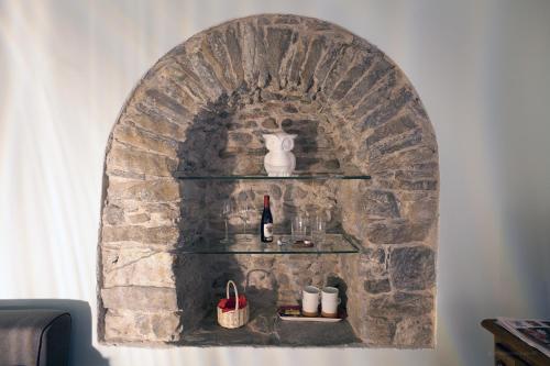 a stone wall with shelves and a bottle of wine at Aymon de Challant in Aosta