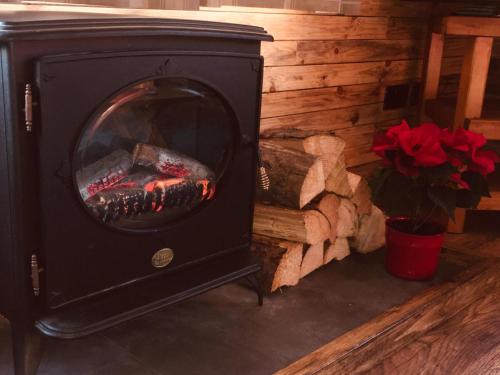 a black wood stove with a fire in it at Sunset Cabin in Mold