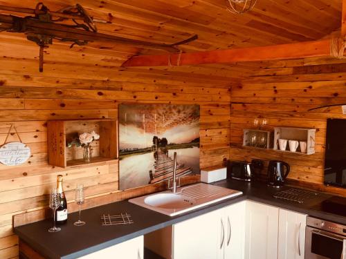 a kitchen with a sink in a wooden wall at Sunset Cabin in Mold