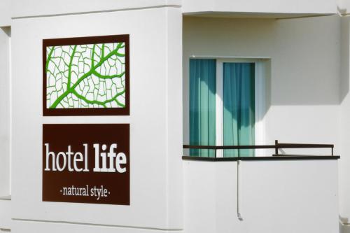 a building with a window and a sign for a hotel life at Hotel Life in Rimini