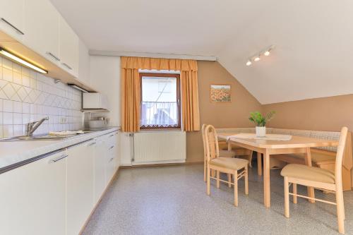 a kitchen and dining room with a table and chairs at Ferienwohnungen Kapp in Tröpolach