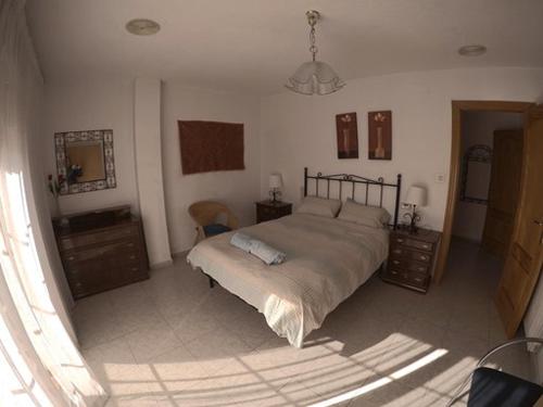 a bedroom with a large bed and a mirror at Casa Ghalia in Cenes de la Vega