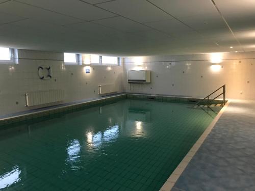 ein leerer Pool mit grünem Fliesenboden in der Unterkunft Nordstern in Cuxhaven