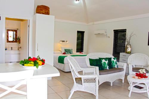 um quarto com uma cama, uma mesa e cadeiras em Makayla Palms em Rarotonga