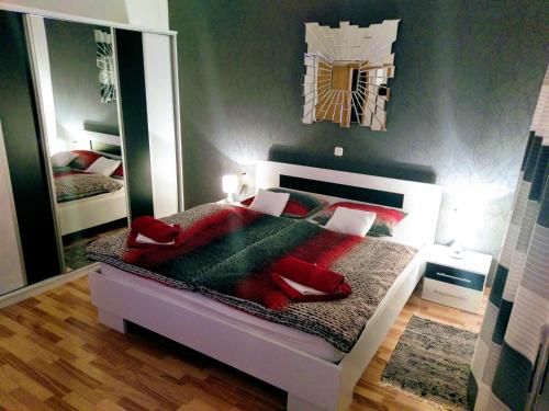 a bedroom with a bed with red pillows and a mirror at Apartment Citadela in Split