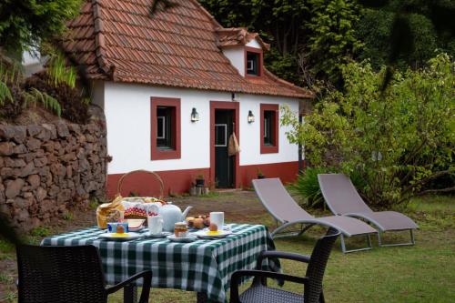 a table with a plate of food in front of a house at Valle Paraizo in Camacha